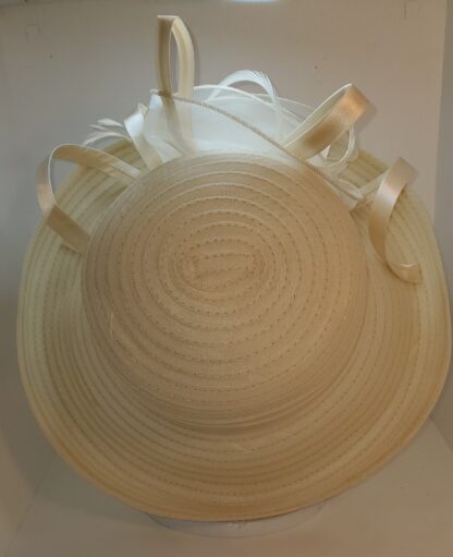 Cream wide brim hat with flower and satin ribbons. Top view.
