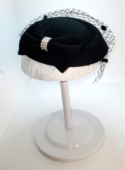 Black bowknot hat with mesh covering. Left side view.